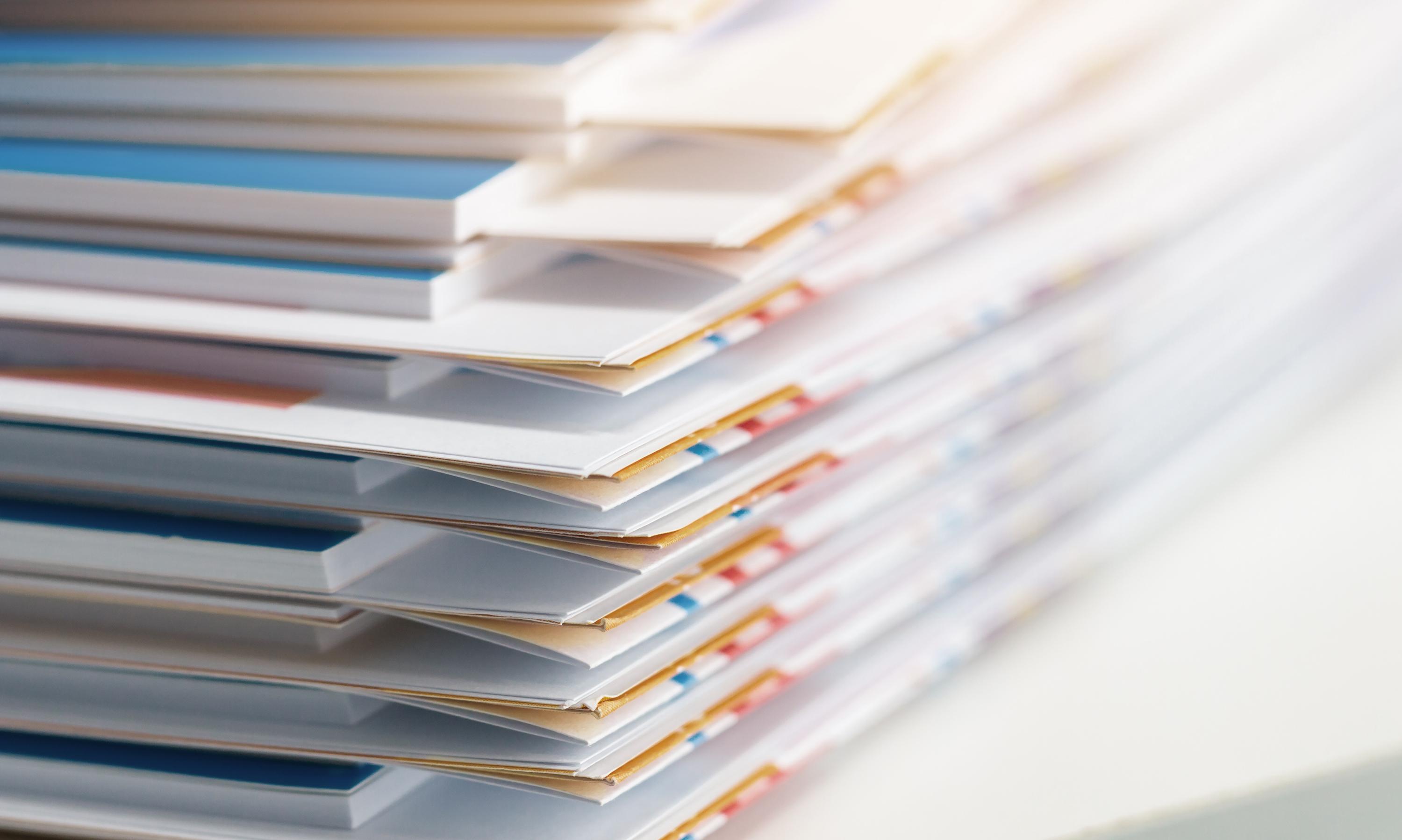 Stacks of organized documents and folders in soft focus.