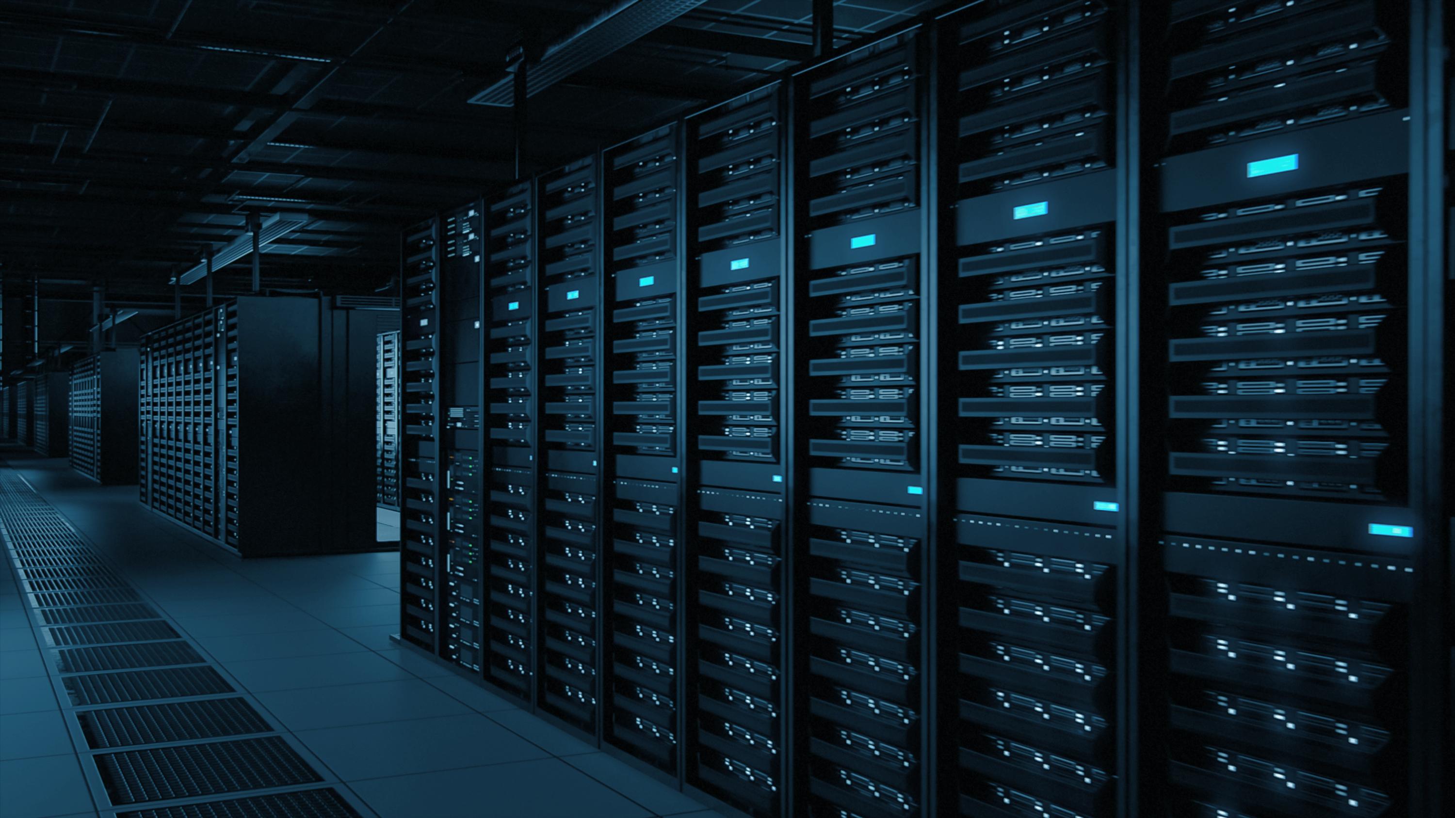 Dark, illuminated server rooms filled with rows of network servers.